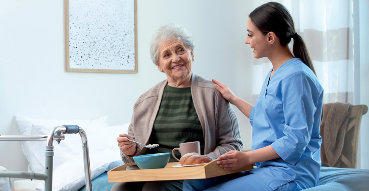 Frau pflegt Seniorin.