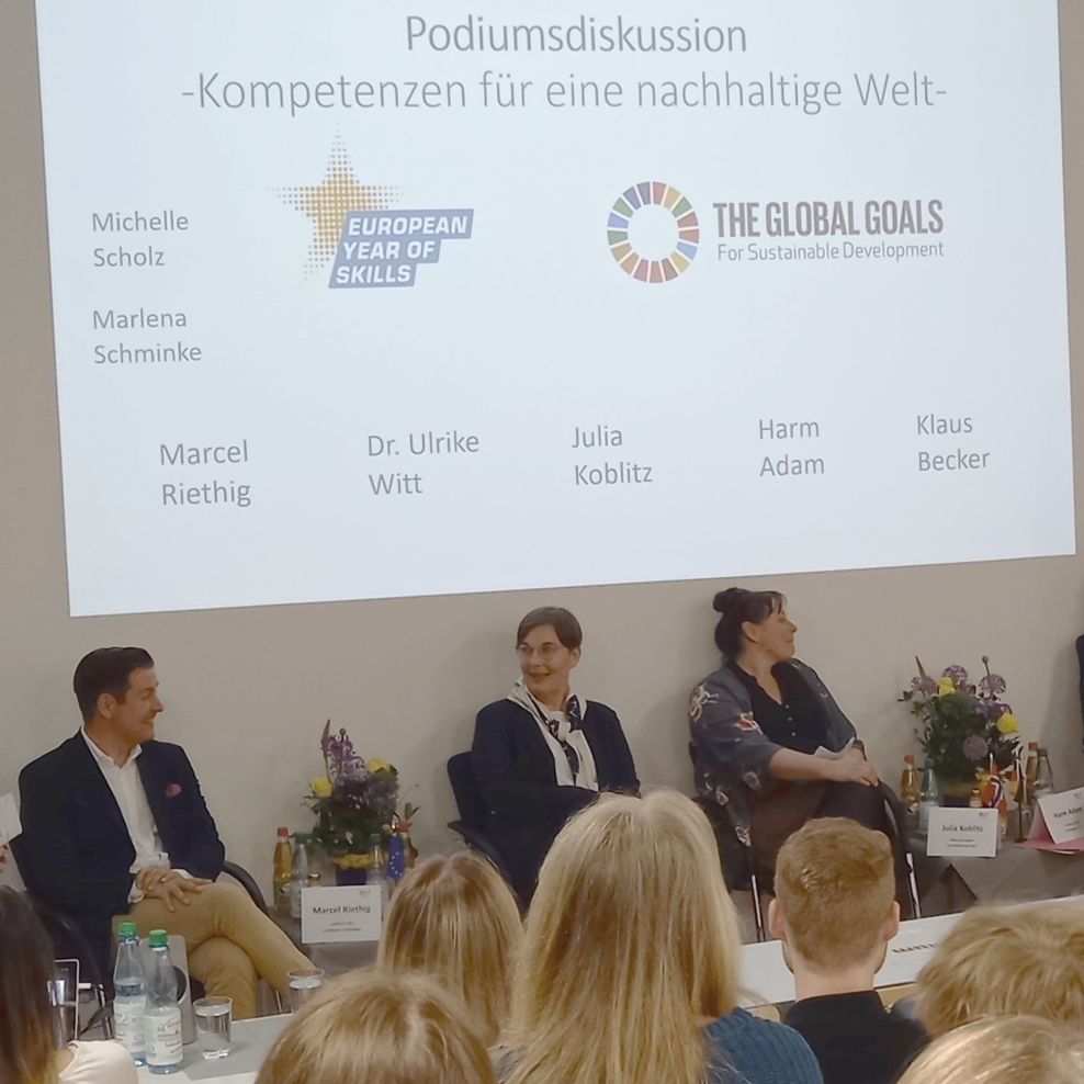 Schülerinnen und Schüler der BBS Göttingen verfolgen im Hörsaal die Podiumsdiskussion.